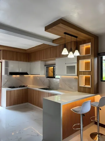 Kitchen set dengan meja bar dan lampu gantung